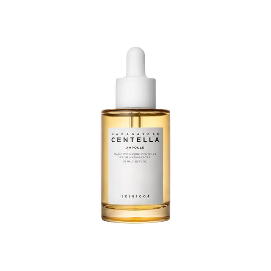 A clear glass bottle with white dropper cap containing golden-yellow madagascar centella ampoule by skin1004