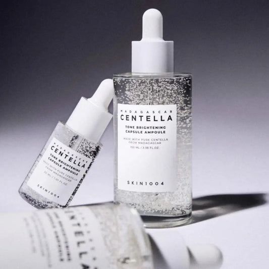 Clear glass bottle with white dropper cap containing sparkling transparent brightening capsule ampoule with madagascar centella