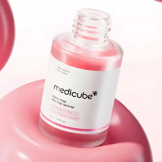 A clear glass bottle of pdrn pink peptide serum 30ml with a white label and pink accents containing pink peptide liquid