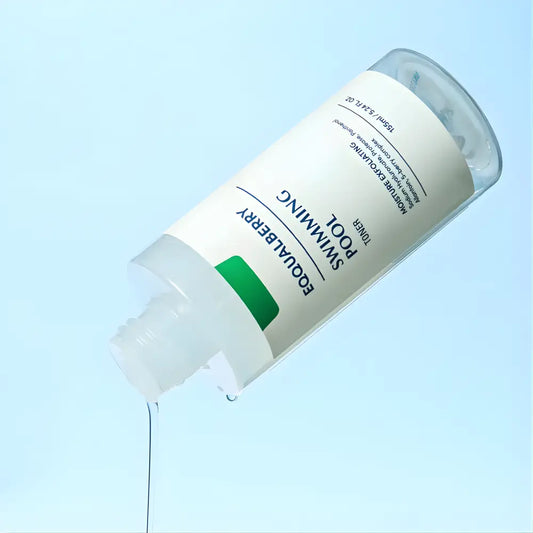 A clear glass bottle with white label and green accent featuring equalberry swimming pool moisture exfoliating toner for skin