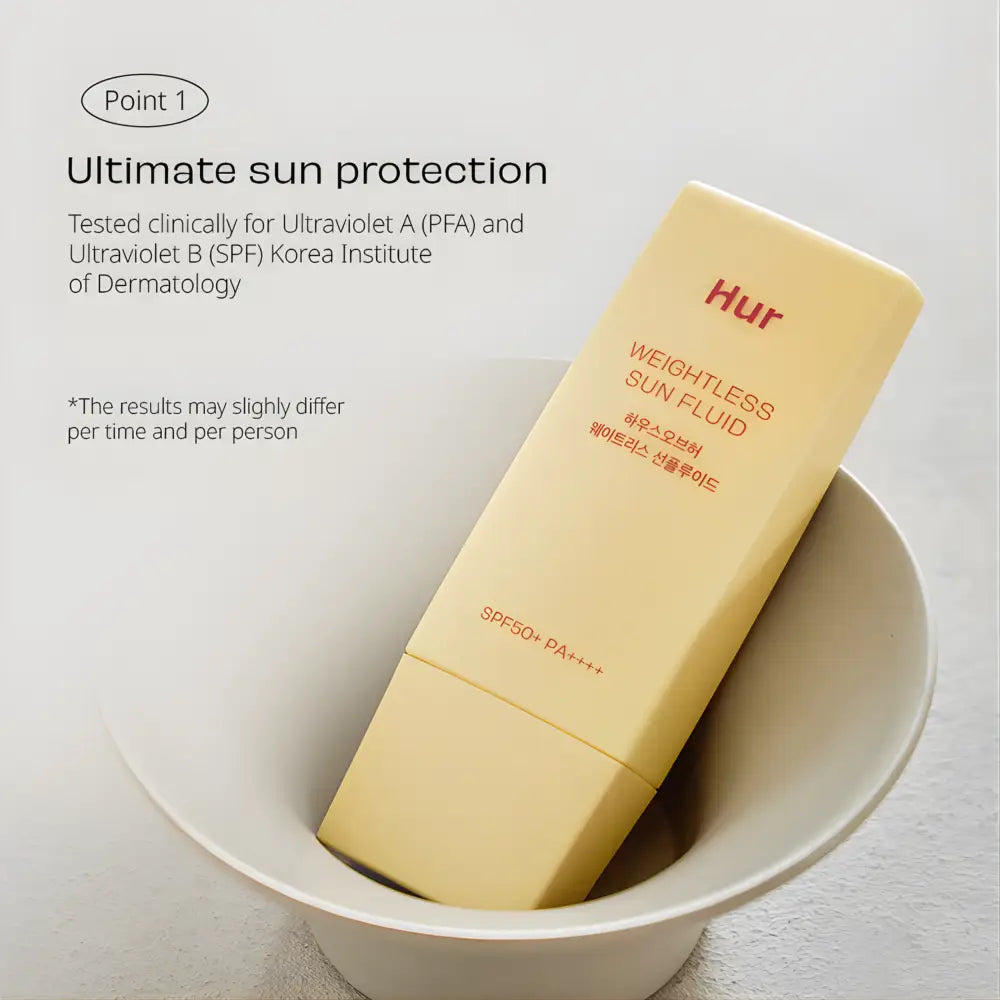 A pale yellow sleek rectangular tube of weightless sun fluid sunscreen with spf 50 plus pa plus plus plus labeling