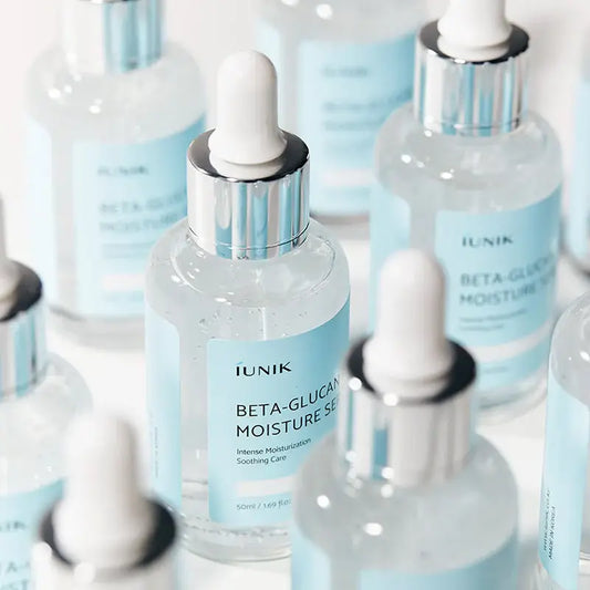 Clear glass bottle with silver dropper cap and white rubber bulb labeled iunik beta glucan moisture serum for hydration layering in korean skincare systems.