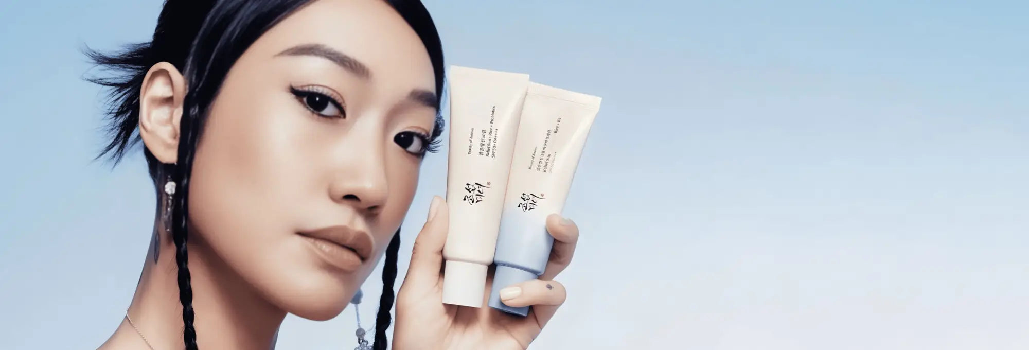 Two sleek cream sunscreen tubes with matte white and soft blue caps highlighting korean skincare south africa trends
