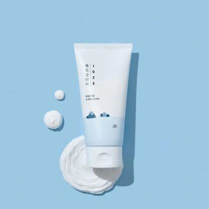 White tube of 1025 dokdo cleanser with minimalist design and blue mountain illustration for authentic k-beauty use