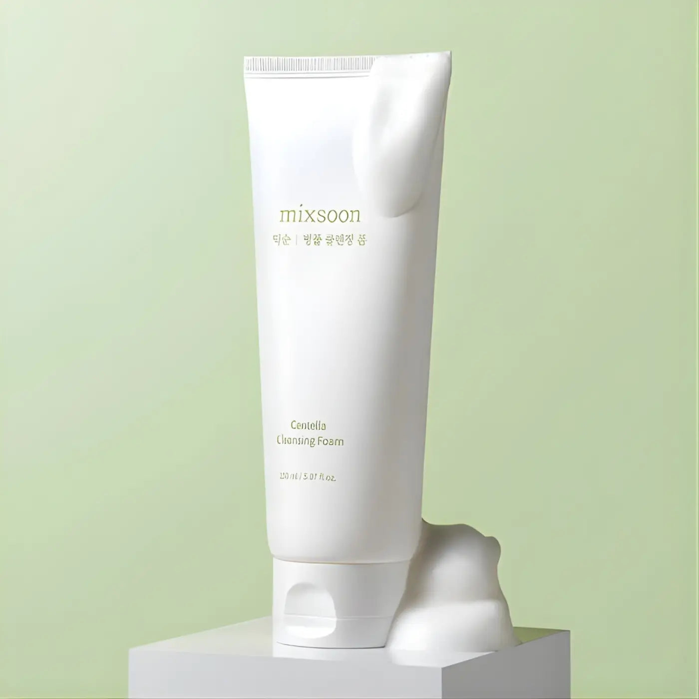 White tube of mixsoon centella cleansing foam 150ml with minimalist gold lettering and soft frothy centella cleansing texture spilling