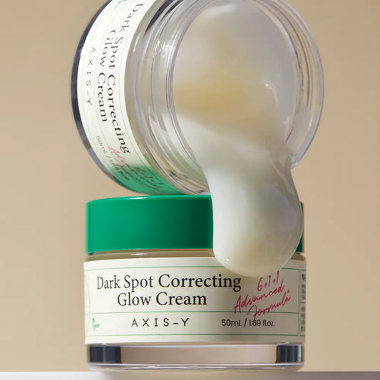 A translucent green-lidded jar of axis-y dark spot correcting glow cream with white cream dripping korean skincare south africa