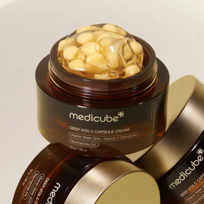 Medicube deep vita c capsule cream 55g in a dark brown jar with gold lid showing yellow vita c capsules in gel
