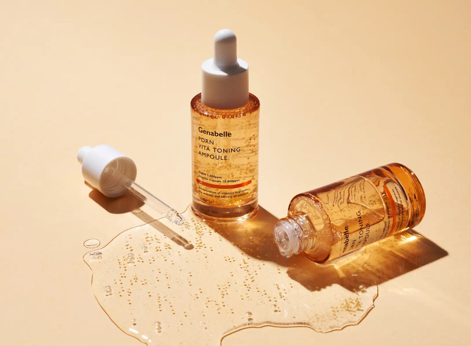 Genabelle pdr vita toning ampoule in a clear glass bottle with an amber tint and white dropper cap, containing golden-hued liquid.