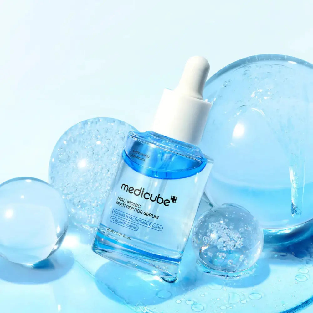 Clear glass bottle of medicube hyaluronic multi peptide serum with white dropper cap and blue liquid 30ml