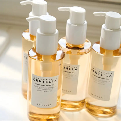 Clear glass bottles with white pumps containing golden madagascar centella light cleansing oil by skin1004 for authentic k-beauty and korean skincare south africa