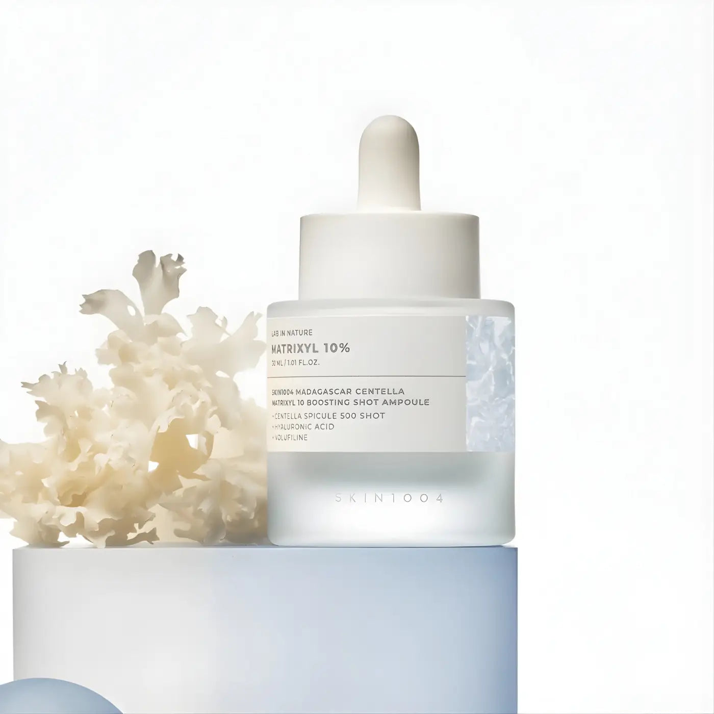A sleek transparent glass bottle with white dropper cap containing madagascar centella matrixyl boosting shot ampoule