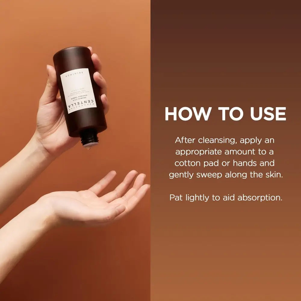 Dark brown cylindrical bottle with white label held in hand featuring madagascar centella probio-cica essence toner 210ml