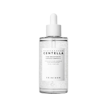 Clear glass bottle with white dropper cap containing madagascar centella brightening capsule ampoule with visible beads