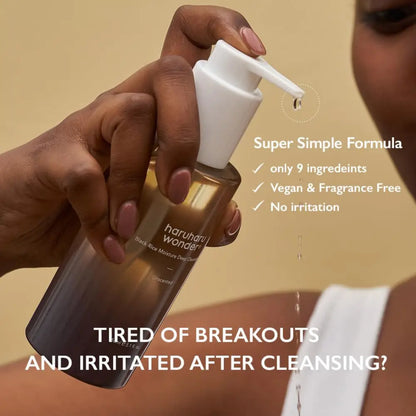 A sleek transparent glass bottle with white pump containing haruharu wonder black rice moisture dew cleansing oil unscented