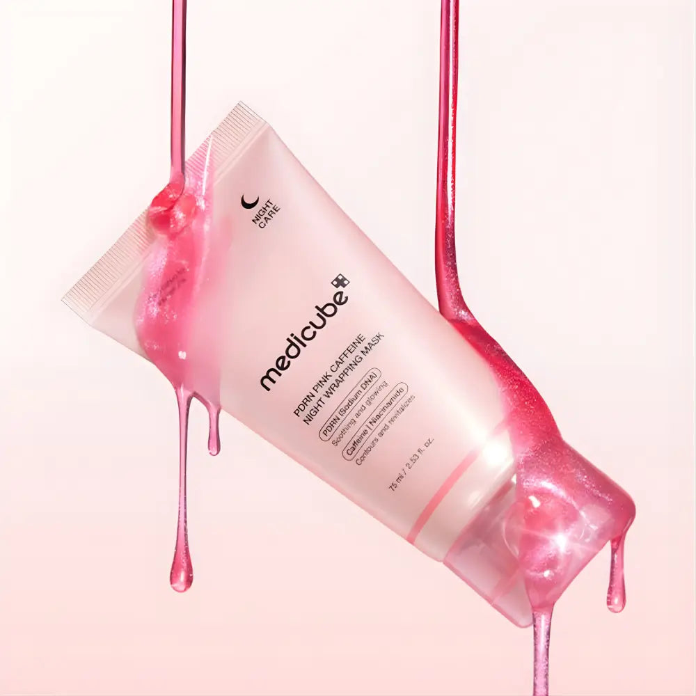 A translucent pink tube of medicube pdrn pink caffeine night-wrapping mask 75ml with product droplets on sides