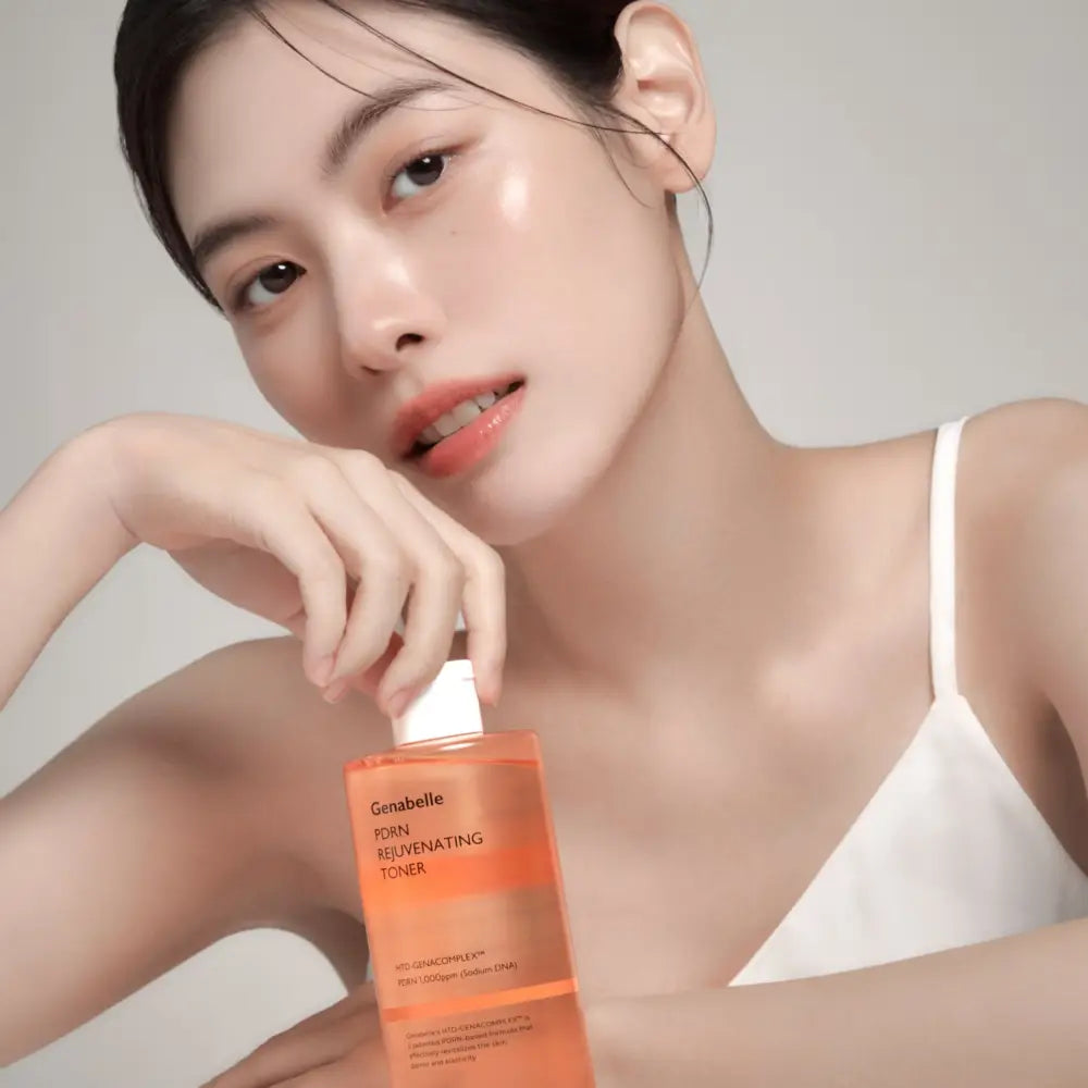 Orange translucent plastic bottle of genabelle pdrn rejuvenating toner for skin with white cap and black text labeling 300ml