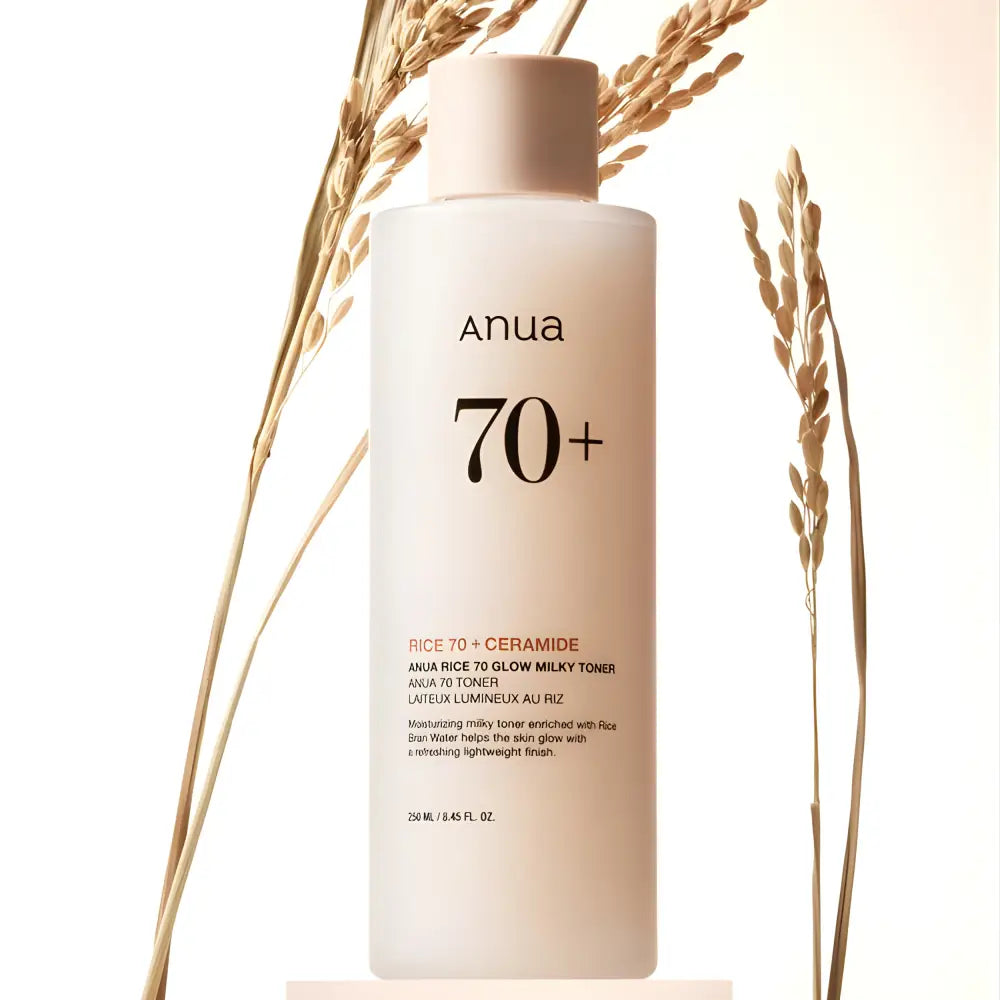 A sleek translucent white bottle of anua rice 70 glow milky toner with a matte pink cap for skin barrier care