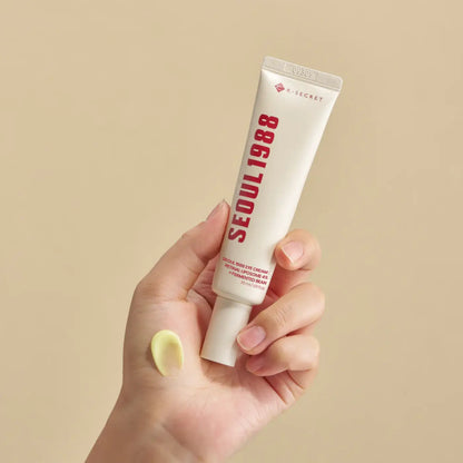 White tube of k-secret seoul 1988 eye cream with red lettering and pale yellow retinal liposome on palm for eye area