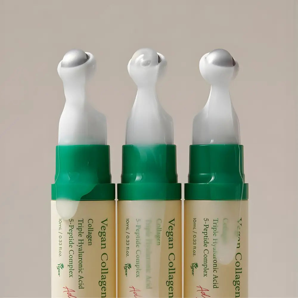 Three identical vegan collagen eye roller pens with translucent beige bodies, green caps, and cooltouch eye applicator tips specifically designed for eye serum application