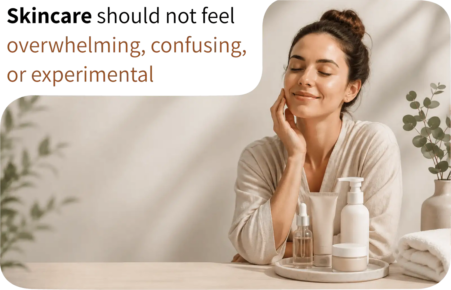 A woman in a beige robe gently touches her cheek, surrounded by minimalist skincare products on a tray.